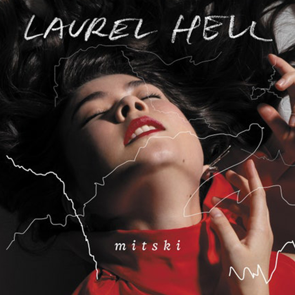 cover of Mitski's Laurel Hell album featuring her in a red turtleneck with red lipstick against a black background with black laurel leaves in the corners. Her eyes are closed and mouth is slightly agape with her top teeth showing. She looks like she's dancing.